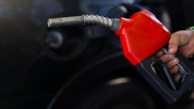 Pumping equipment gas at gas station. Close up of a hand holding fuel nozzle 