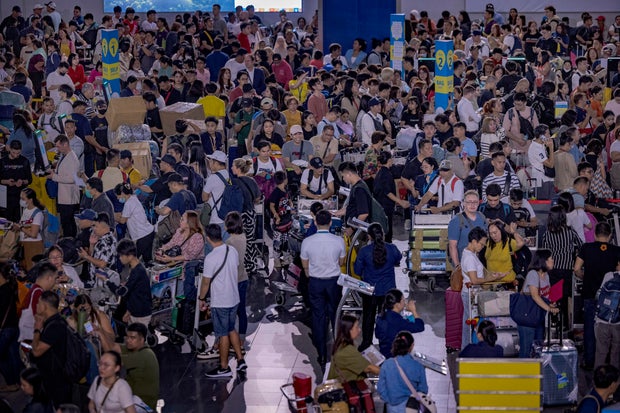 Long lines of passengers form at check-in counters at Ninoy Aquino International Airport amid a global IT disruption caused by a Microsoft outage and a CrowdStrike problem July 19, 2024, in Manila, Philippines. 