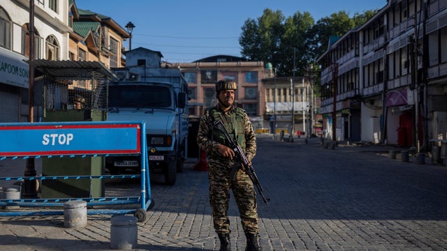 An Indian security force personnel stands guard on a street in Srinagar 