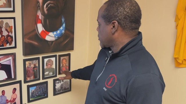 Damone Jones points to a photo on his wall 
