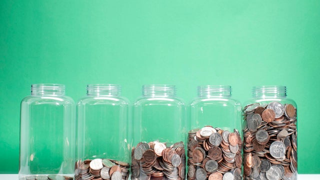 Savings growth concept - 5 jars of coins ascending 
